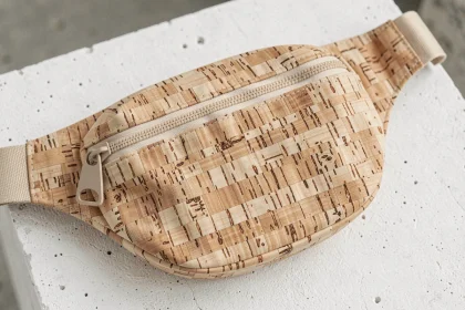 Sac banane tendance en liège texturé posé sur béton blanc, détail de matière originale et coutures fines